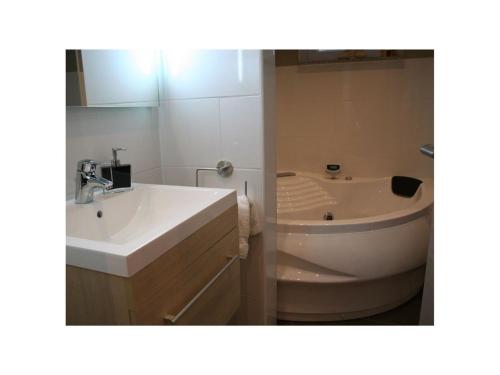a bathroom with a sink and a bath tub at Lovely apartment near centre in Holzminden