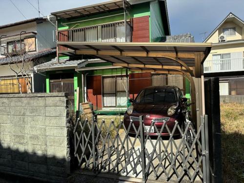 a car parked under a gate in front of a house at 高知県　みどりの家 in Gomen