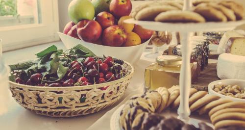 a table with baskets of fruits and vegetables and cookies at Langhe Country House in Neive