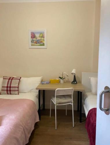 a bedroom with a desk with a chair and a table at Lovely Private Rooms in Camden, Central London in London
