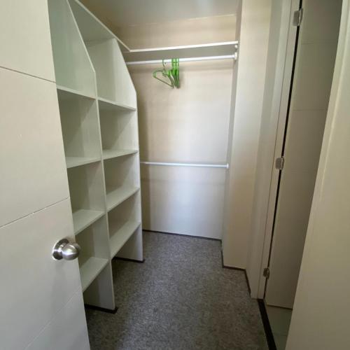 um closet com prateleiras brancas e uma porta em Apartamento Barcelona Miró N&A em Santiago