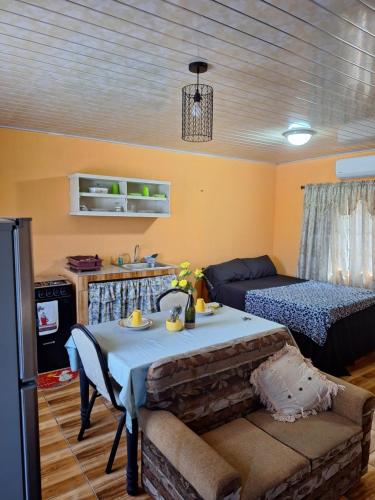 a living room with a table and a bed at Valsalms in Chaguanas