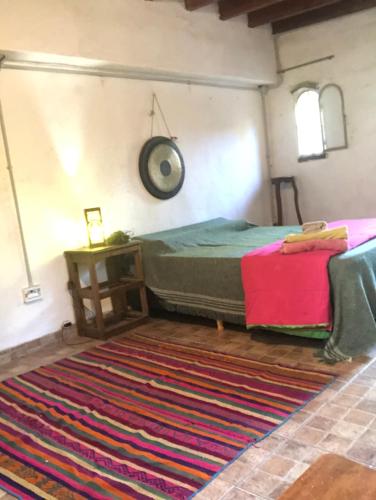 a bedroom with a bed and a rug on the floor at Sonqo Wasi in Cruz del Eje