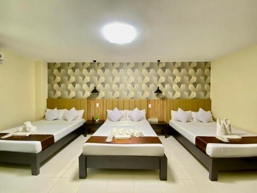 two beds in a room with two bedsitures at Hotel Dorotea in Puerto Galera
