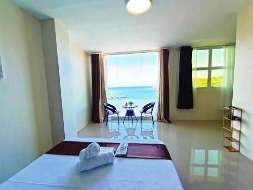 a room with a bed with a view of the ocean at Hotel Dorotea in Puerto Galera