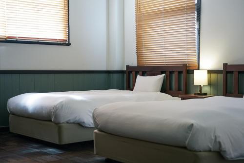 豊岡市にあるToyooka1925のベッドルーム1室(隣り合わせのベッド2台付)