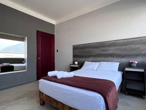 a bedroom with a large bed and a red door at Depa doble centrico con Restaurante Terraza in Orizaba