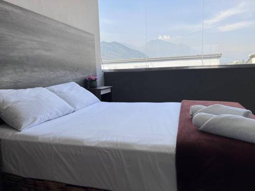 a bedroom with a white bed and a large window at Depa doble centrico con Restaurante Terraza in Orizaba