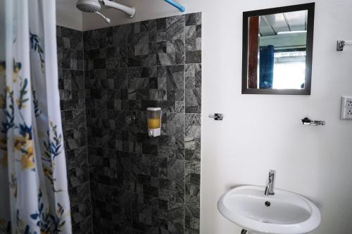 La salle de bains est pourvue d'un lavabo et d'un miroir. dans l'établissement House in the palm forest, à Carrillo