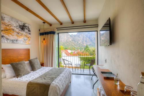 a bedroom with a bed and a large window at Casa Ehua Hotel Galería in Tepoztlán