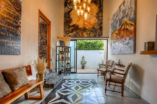 a living room with a chandelier and a table and chairs at Casa Ehua Hotel Galería in Tepoztlán