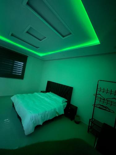 um quarto com uma cama com luz verde em شقه غرفه وصاله مريحه em Riyadh