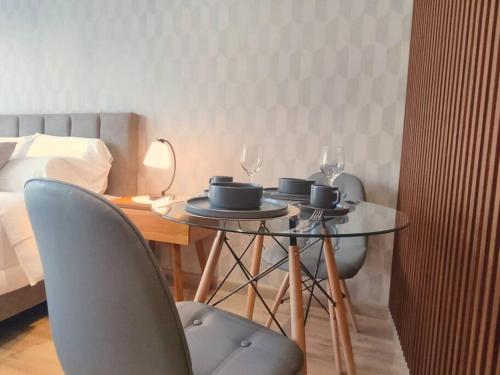 een tafel met twee stoelen en twee wijnglazen erop bij BeKAWS: Suite in Quito