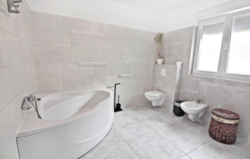 a white bathroom with a tub and a toilet at Family friendly house with a swimming pool Buroli, Umag - 22400 in Umag