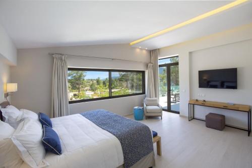 a bedroom with a large bed and a large window at Villa Lagoon in Vourvourou