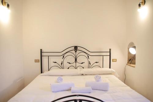 uma grande cama branca com duas toalhas brancas em Be My Guest Perugia em Perugia
