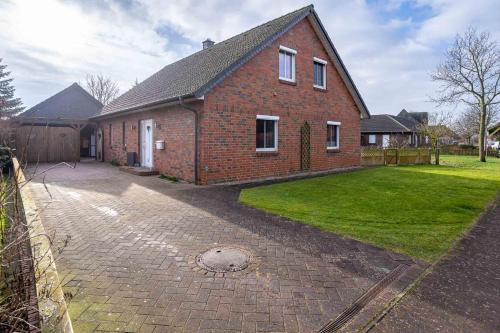 a red brick house with a driveway in front of it at Urlaubsnest an der Eider in Tönning