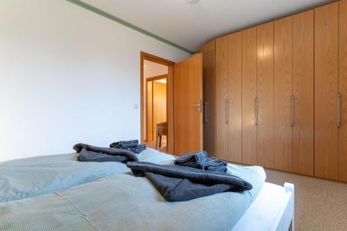 a bedroom with two beds and wooden cabinets at Urlaubsnest an der Eider in Tönning