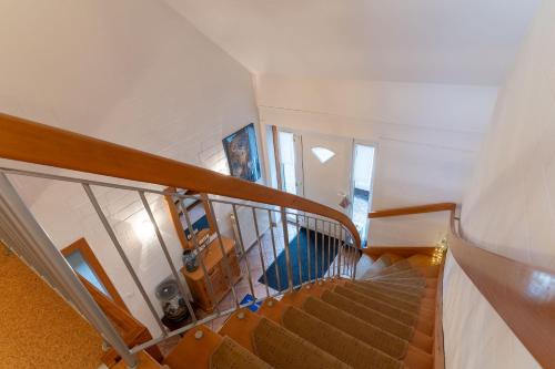 a staircase in a house with a wooden stair case at Urlaubsnest an der Eider in Tönning