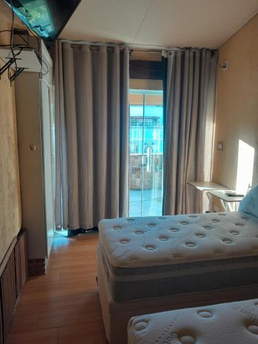 里約熱內盧的住宿－Cobertura Copacabana，一间卧室设有两张床和滑动玻璃门