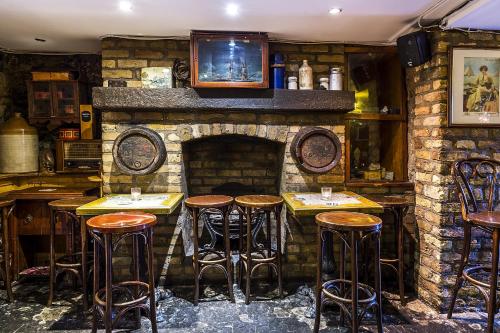 a bar with wooden stools and a stone fireplace at Uppercross House Hotel in Dublin