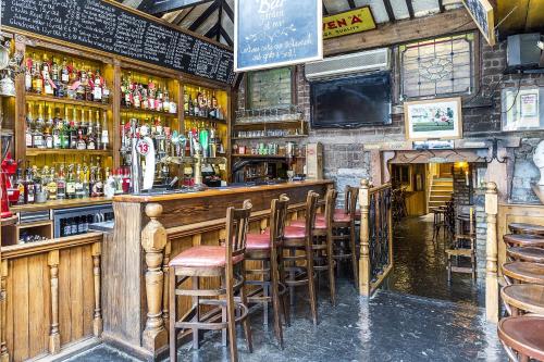a bar with a bunch of bar stools at Uppercross House Hotel in Dublin
