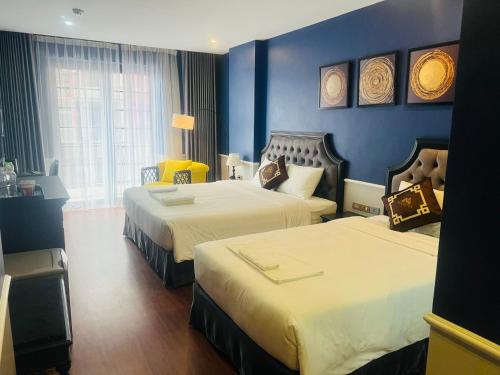 - 2 lits dans une chambre d'hôtel aux murs bleus dans l'établissement TGlobal Marina Tam Dao Hotel, à Tam Ðảo