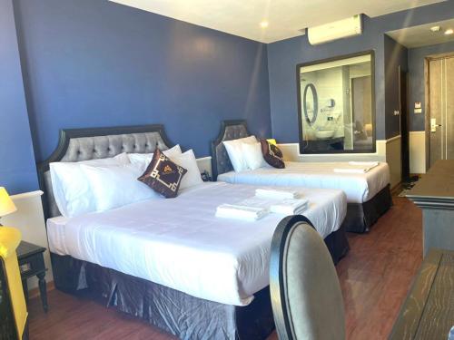 Cette chambre comprend 2 lits et un miroir. dans l'établissement TGlobal Marina Tam Dao Hotel, à Tam Ðảo