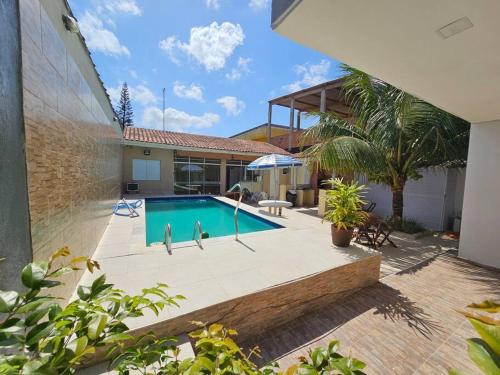 uma piscina no quintal de uma casa em casa c/piscina enseada guaruja no Guarujá