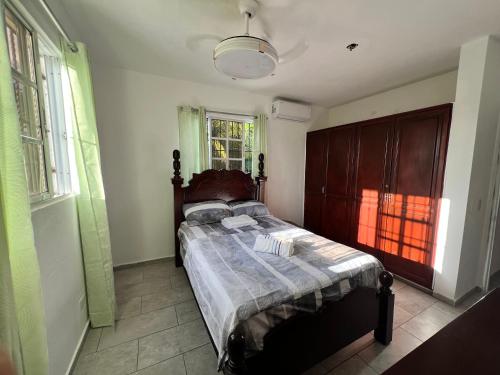 - une chambre avec un lit dans une pièce dotée de fenêtres dans l'établissement City suite Sosua AptStudio, à Sosúa