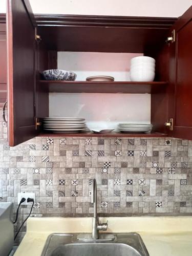 une cuisine avec un évier et un comptoir avec de la vaisselle dans l'établissement City suite Sosua AptStudio, à Sosúa