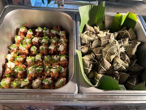 two metal trays filled with food and sidxbestosbestosbestosbestosbestosbestosbestos at Tzu Chi Hotel in Pingtung City