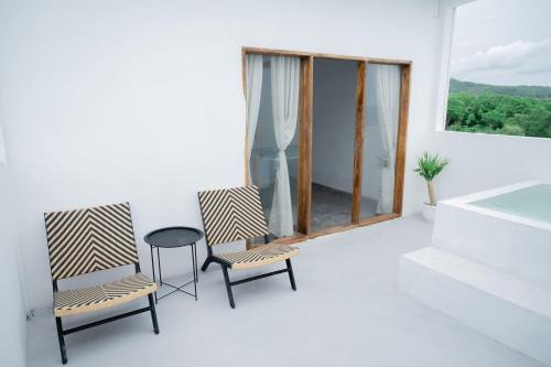 two chairs and a table in a room with a window at Woywoy Paradise in Bira