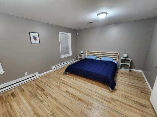 a bedroom with a bed and a wooden floor at Mins to NYC- 3Bed Superb Fully Furnished in Jersey City