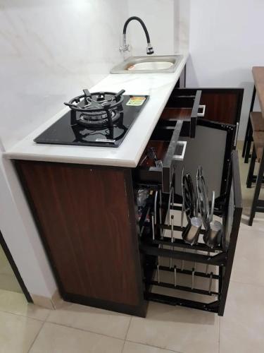 a kitchen counter with a stove and a sink at Puri Kanata in Pampang