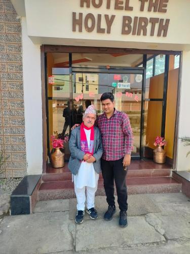 a man and a woman standing in front of a building at Hotel The Holy Birth in Lumbini