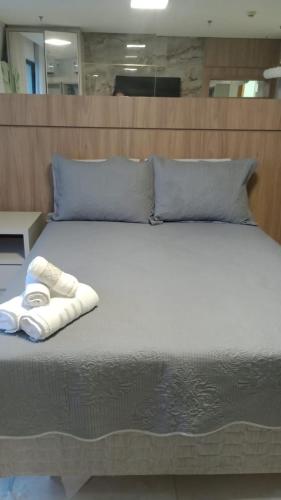 una cama con un par de toallas sentadas en ella en Inova Flat completo no Condominio Cosmopolitan, en Palmas