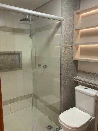 y baño con aseo y ducha acristalada. en Inova Flat completo no Condominio Cosmopolitan, en Palmas