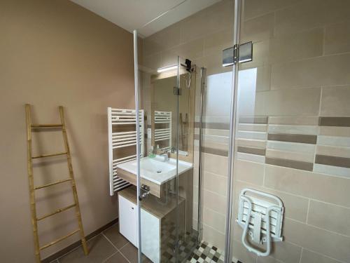 a bathroom with a sink and a glass shower at Pretty holiday home in Cotentin in Gouville-sur-Mer