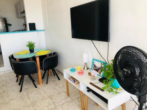 ein Wohnzimmer mit einem Tisch und einem Flachbild-TV in der Unterkunft @casa_grace Bienvenidos! in Cartagena de Indias
