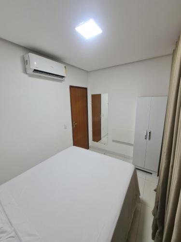 a white room with a bed and a window at Bahia Trip Flats in Lençóis