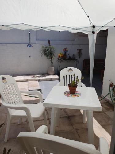 a patio with a table and chairs and an umbrella at Quincho Los Abuelos in Chivilcoy