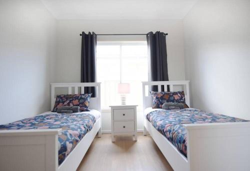 sypialnia z 2 łóżkami i oknem w obiekcie Poseidon's Oasis - Entire Home - Moonta Bay w mieście Port Moonta