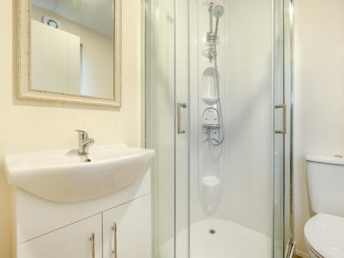 a white bathroom with a sink and a shower at Wainstones Rocks - Uk42938 in Great Broughton