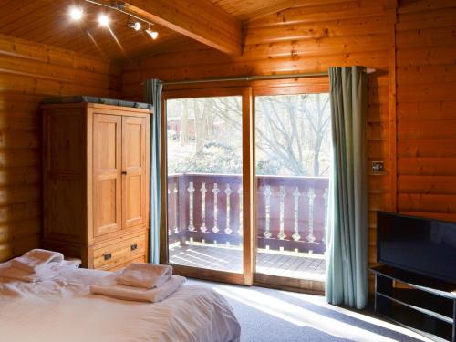 a bedroom with a bed and a sliding glass door at Red Kite Lodge in Legbourne