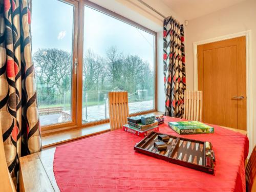 a room with a red bed with a large window at Wernddu Fechan House - Uk42932 in Neath