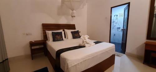 a bedroom with two beds and a door to a room at The Otunna Guest House Sigiriya in Sigiriya