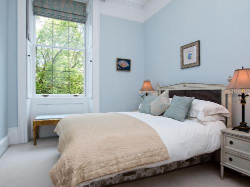 Royal Crescent Apartment في باث: غرفة نوم بيضاء مع سرير كبير ونافذة