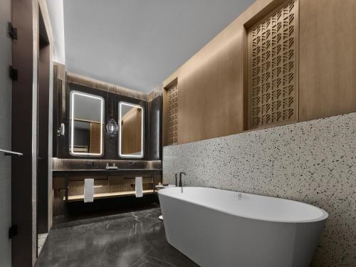 a bathroom with a large tub and a sink at Banyan Tree Suzhou Shishan in Suzhou