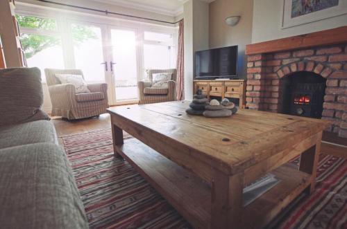 un soggiorno con tavolo in legno e camino di Oceanview House a Ballycastle